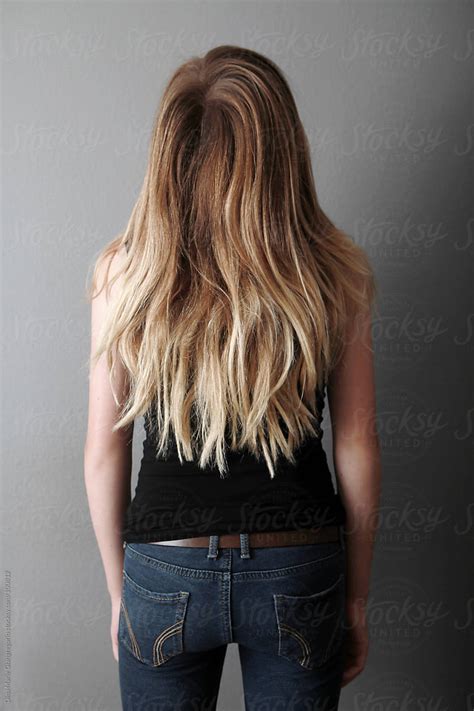 Backside Of Teenager With Long Hair Wearing Jeans And Black Tank Top By Stocksy Contributor
