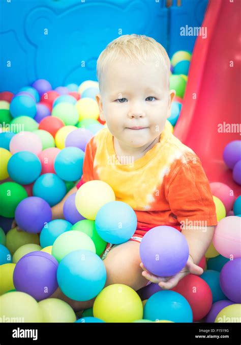 Cute Kid Boy Playing With Colorful Balls Stock Photo Alamy