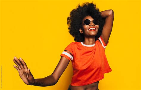 Happy Afro Woman Posing Over Yellow Background By Stocksy Contributor