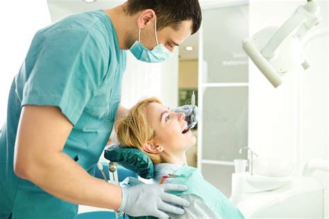 O Dentista Trata Os Dentes Da Menina Paciente Foto De Stock Imagem De