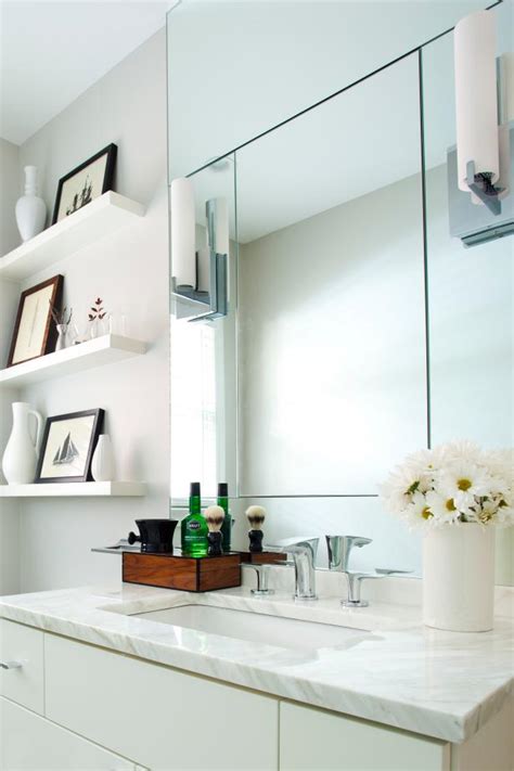 The bathroom design should give a sense of calm and relaxing atmosphere, and modern bathrooms provide this environment with their sleek looks. Modern White Bathroom with Mirrors and Open Shelving | HGTV