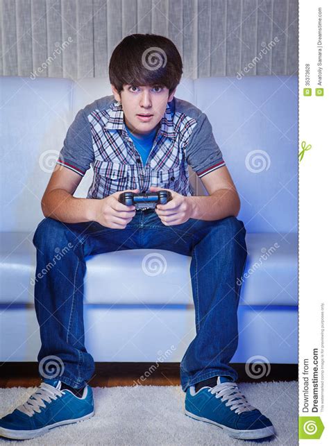 Sad Teenage Gamer Sits At Home Behind A Computer And Plays Video Games