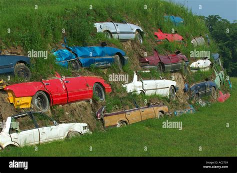 Salvaged Cars Buried In The Side Of A Hill Stock Photo Alamy