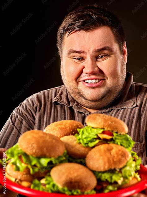 Fat Man Eating Fast Food Hamberger And Carries Treat For Friends On