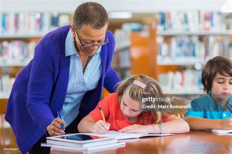 Teacher Helping Student In Library High Res Stock Photo Getty Images
