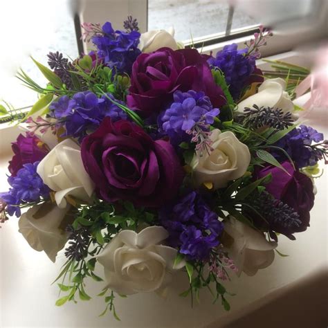 A Flower Arrangement Of Purple And Ivory Roses And Foliage Large Flower