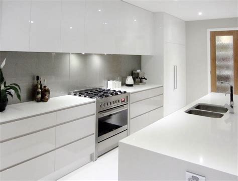 Easy to clean indoor area rug. White cupboards, no handles, light grey splashback, all in one cooker | White modern kitchen ...