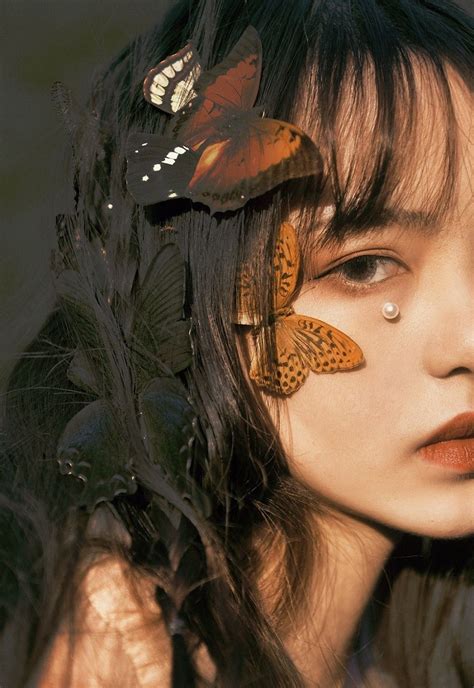 A Woman With Two Butterflies On Her Face And One Butterfly On Her