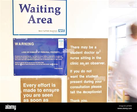 Waiting Area Signage In A Nhs Uk Hospital As A Doctor Walks Through The