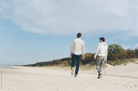 Young Men Walking On Beach On Sunny Day With Sand Dunes By Stocksy