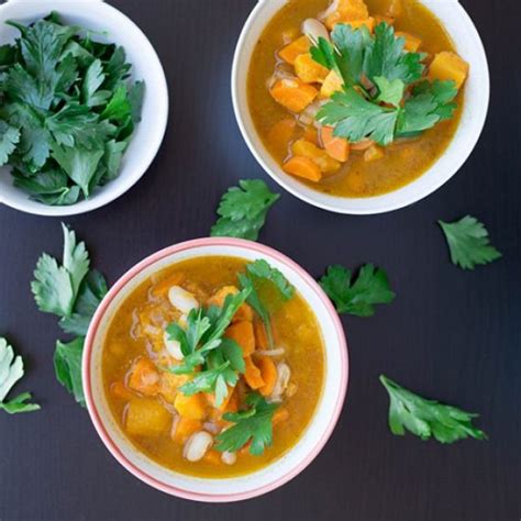 Three Bowls Of Soup With Carrots Celery And Parsley On The Side
