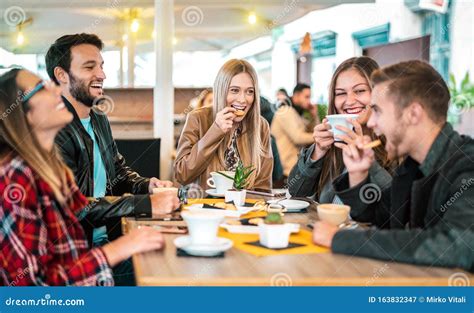 Grupo De Amigos Tomando Capuchino En El Café Bar La Gente Hablando Y