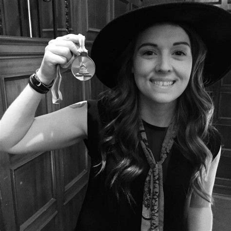 A Woman Wearing A Hat And Holding A Wine Glass