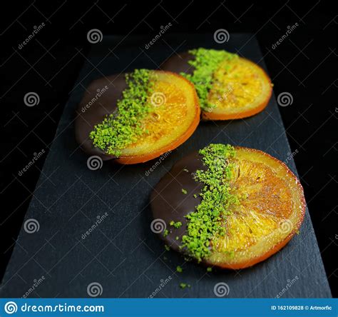 Caramelized Christmas Oranges In Chocolate With Green Pistachios Stock