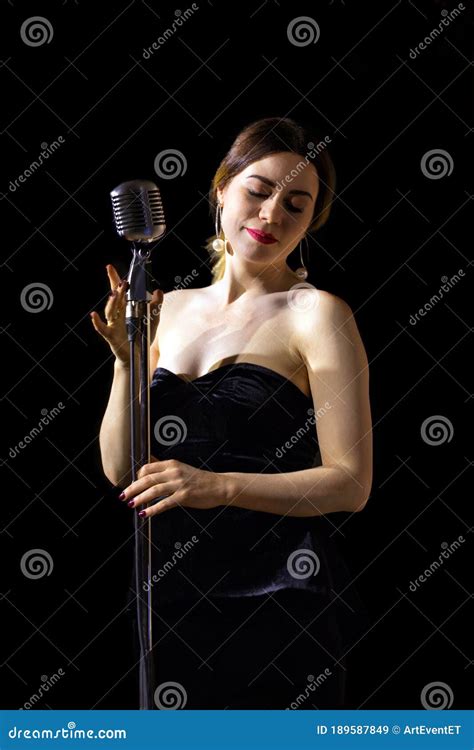 Beautiful Woman Singing On Vintage Microphone On Black Background Stock