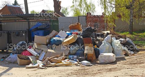 huge pile of household rubbish piled up next to empty trash cans boorish attitude of people