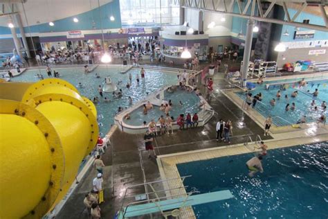 An Indoor Swimming Pool Filled With People And Large Yellow Buoy Next