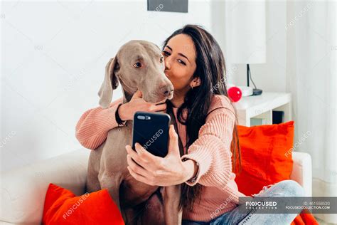 Loving Female Owner Hugging And Kissing Adorable Purebred Weimaraner