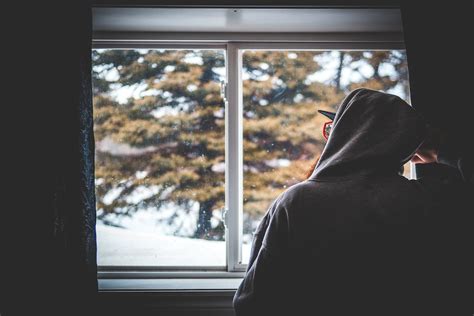 Anonymous Male Looking Out Window On Winter Day · Free Stock Photo