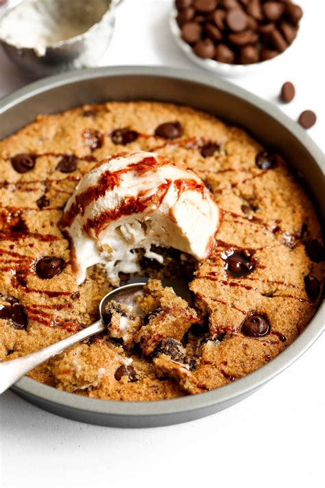 A Cookie With Ice Cream And Chocolate Chips On The Side Is Being Eaten