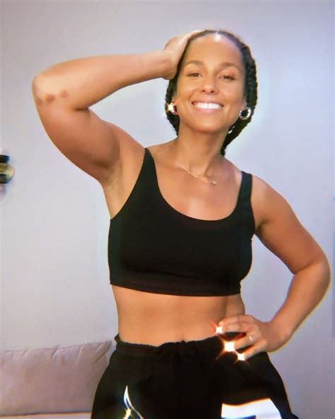 A Woman With Her Hands On Her Head And Wearing Black Sports Bra Top Standing In Front Of A Couch