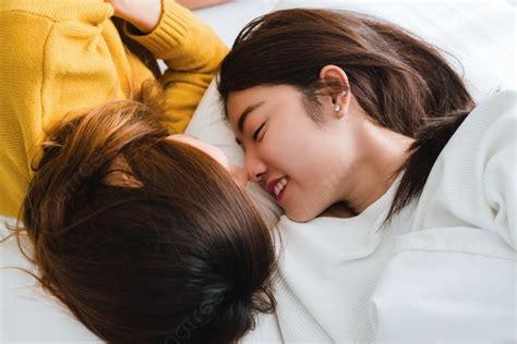 美しい若いアジアの女性 Lgbt レズビアンの幸せなカップルが自宅の毛布の下でベッドに一緒に横たわりながら抱き合って笑顔で目を覚ますと面白い女性 Lgbt レズビアン カップルが一緒に屋内で