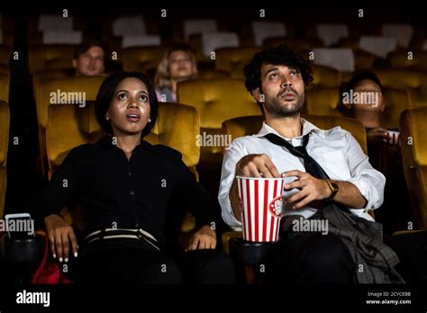 Audience Sitting In A Cinema And Watching Terrible Horror Afraid Woman