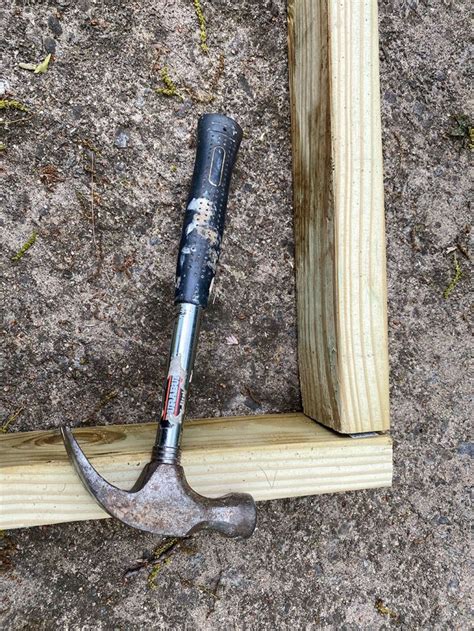 An Old Hammer Is Stuck Into A Piece Of Wood