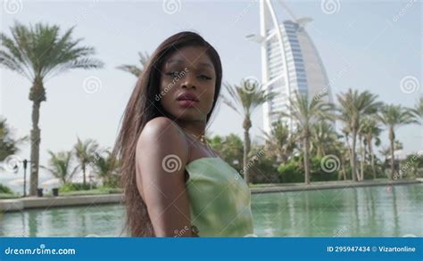 Relaxed Interracial Woman In A Dress Stands At The Bow Of A Boat Passing Through A Canal In