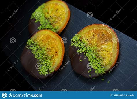 Caramelized Oranges In Chocolate With Green Pistachios Stock Photo