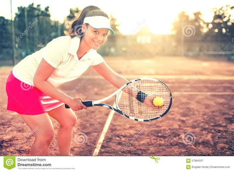Young Girl With Racket On Tennis Court Smiling Stock