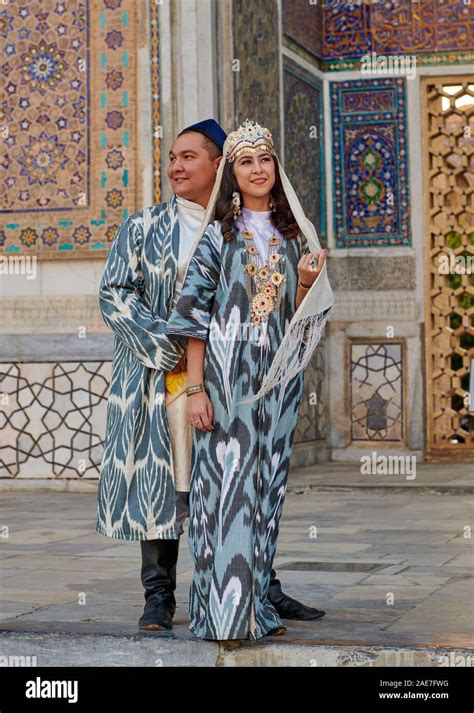 Bridal Couple In Traditional Clothes Posing In Front Of Famous Registan Square Samarkand