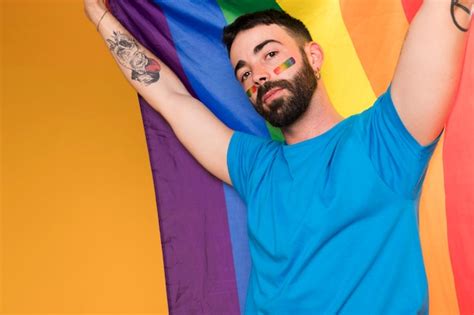 hombre con arcoiris lgbt en la cara con bandera multicolor foto gratis