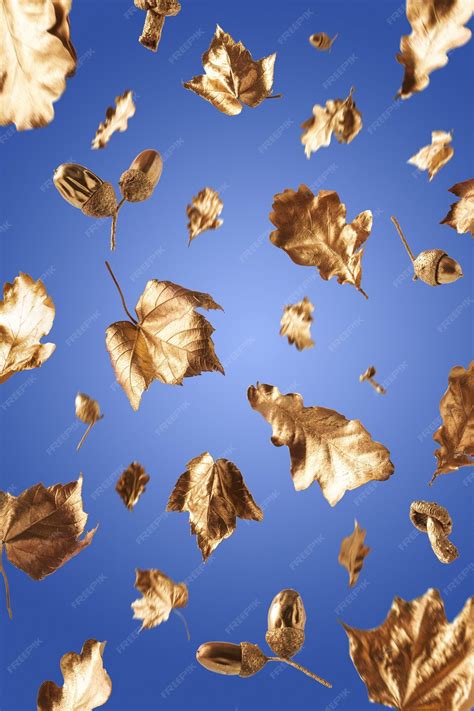Premium Photo Golden Autumn Leaves Falling On A Blue Background