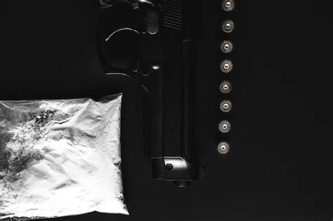 premium photo gun with bullets lying on the table criminal problems drugs and on black