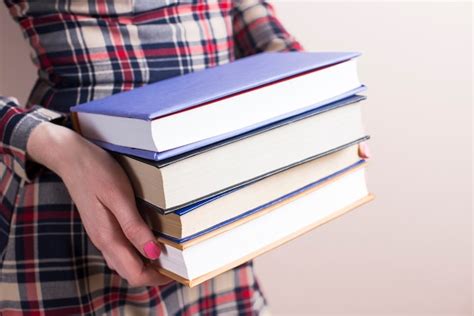 Free Photo Close Up Of Hands With Four Thick Books