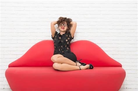 Premium Photo Relaxed Girl Sitting On Red Sofa Sexy Model On Leather Couch Beautiful