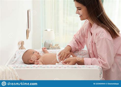 Mother Changing Baby S Diaper On Table At Home Stock Photo Image Of