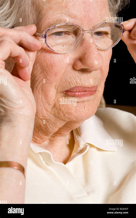 An Old Woman Adjusting Her Glasses Uk Stock Photo Alamy