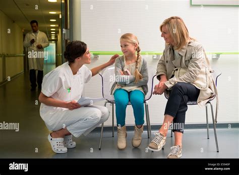 Female Nurse Talking With Patients In Waiting Room Stock Photo Alamy