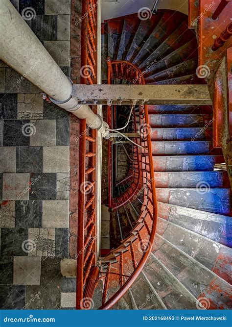 Old Ruined Spiral Staircase With Wooden Stairs And Red Railings In Old