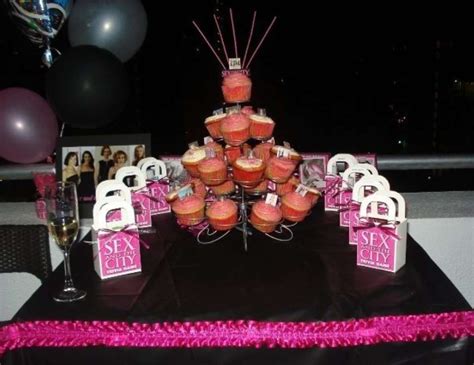 A Table Topped With Lots Of Cupcakes Covered In Frosting And Pink Decorations