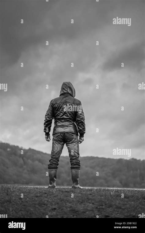 Portrait Mono Rear View Of Isolated Man Standing In Wellies Coat