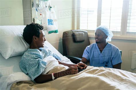 Black Nurse Talking To Boy In Hospital Bed Stock Photo Dissolve