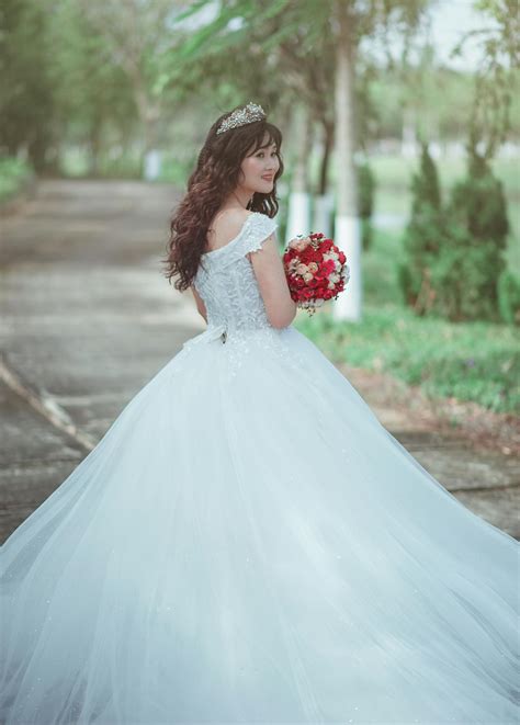 Woman In White Wedding Dress Holding Red Bouquet · Free Stock Photo
