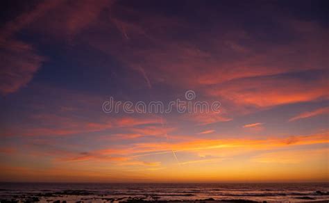 Beautiful Vivid Sunset Sky Over Ocean With Red Clouds And Blue Yellow