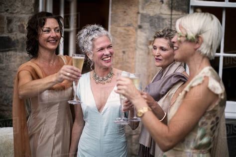 Elegant Mature Women Enjoying Champagne In Urban Garden Stock Photo