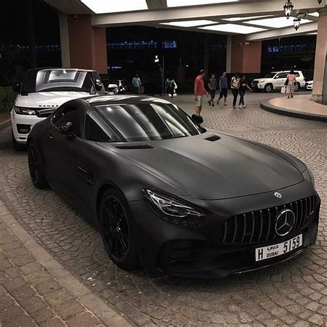 Two Cars Parked Next To Each Other In Front Of A Building With People