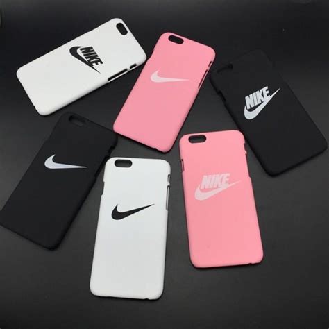 Four Nike Phone Cases Sitting Next To Each Other On A Black Table With