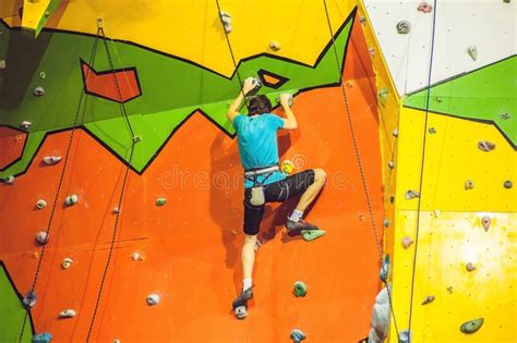 Man Climber On Artificial Climbing Wall In Bouldering Gym Stock Image